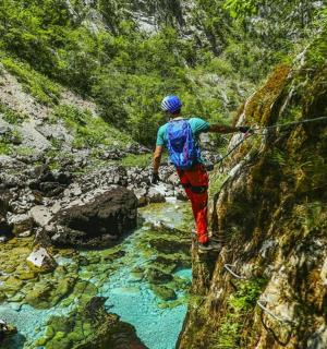 a man walking on a rope over a river