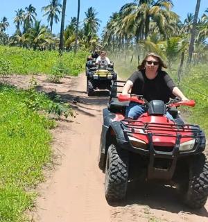 a man riding on a four wheeler on a dirt road