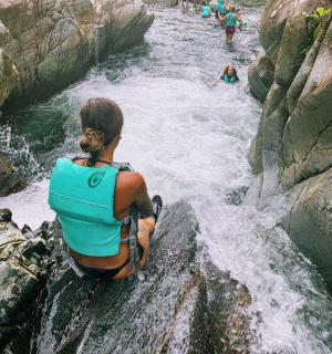 a woman sitting on a rock in a river