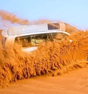 ein SUV, der durch ein Sandfeld fährt