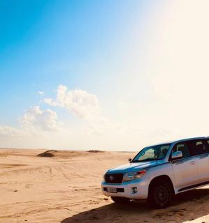 ein weißer LKW, der im Sand in der Wüste geparkt ist