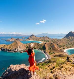 a woman standing on top of a mountain with a frisbee