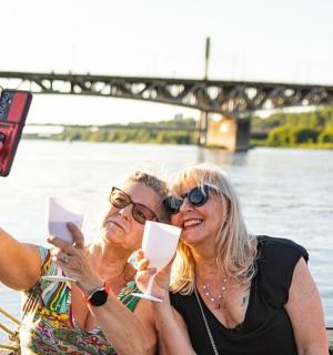 two women taking a picture on a boat on the water