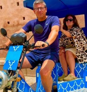 a man and a woman sitting on a scooter