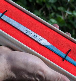 a hand holding a red clipboard with two needles