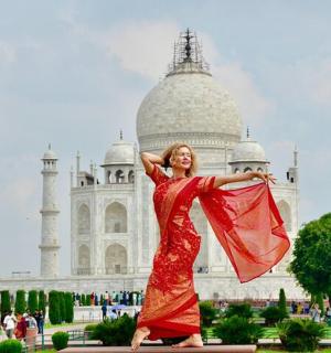 a woman in a red dress standing in front of a building