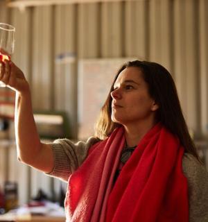 a woman is holding up a glass of wine