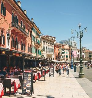 městská ulice se stoly a lidmi sedícími u stolů