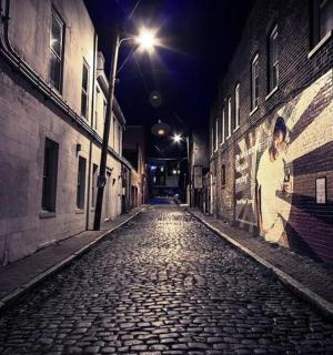 an empty alley at night with a street light