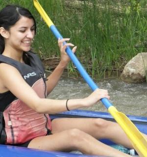 a woman sitting in a boat with two oars