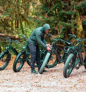 a man is standing next to two bikes
