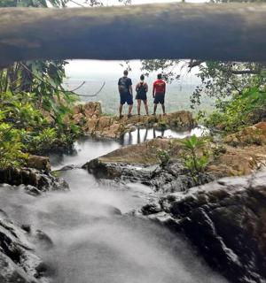 three people standing on a bridge over a river