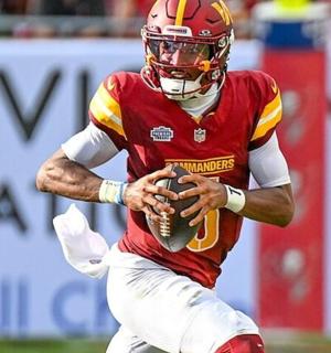 一名足球运动员在球场上拿着球