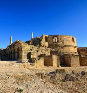 an ancient building in the middle of a field