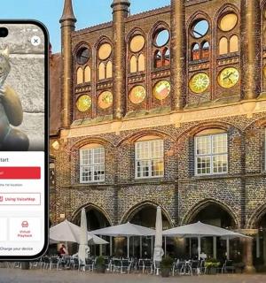 mobilní telefon se sochou před budovou