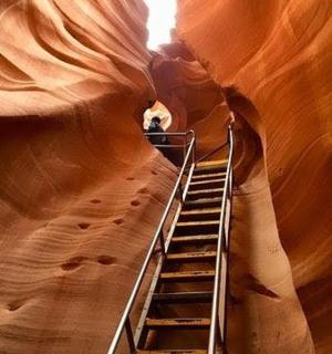 a staircase in a slot canyon with a person on it