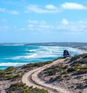 a person sitting on a hill overlooking the ocean