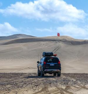 一辆停在大沙丘前的汽车