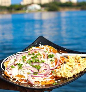 a person holding a plate of food with rice and onions