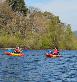 a group of people riding on kayaks on a lake