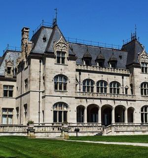 velká kamenná budova se zeleným trávníkem před ní