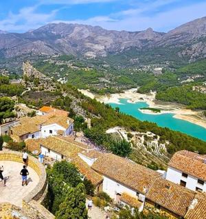 a view of a town with a river and mountains