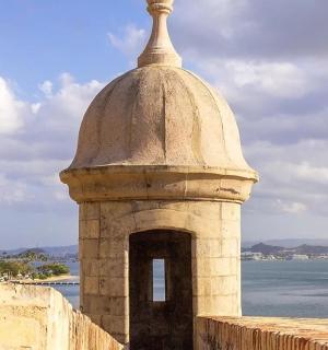 a clock tower on a wall next to the water