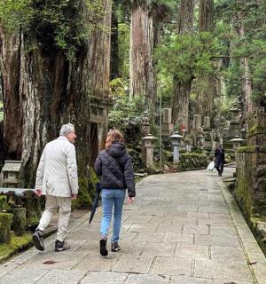 a man and a woman walking through a cemetery