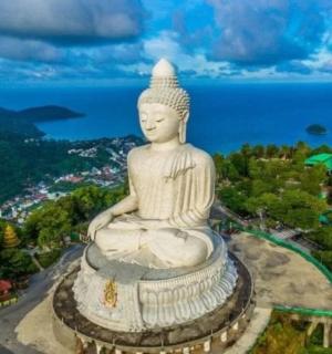 a large statue in front of the ocean
