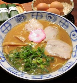 a bowl of soup with meat and vegetables on a table