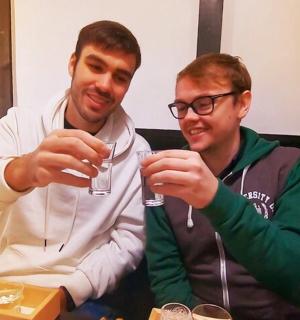 two men sitting at a table holding wine glasses