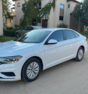 a white car parked in front of a house