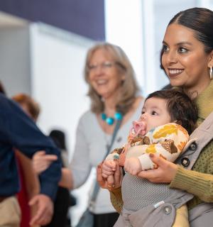 žena držící dítě v nosítku