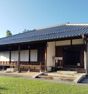 a building with a roof on top of a grass field