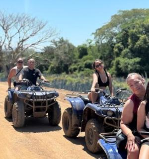 a group of people riding atvs on a dirt road