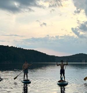 a group of three men are paddleboarding on a lake