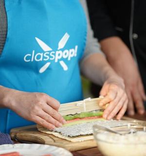 a group of people preparing food on a cutting board