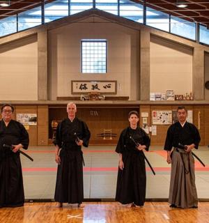 a group of people standing in front of a basketball court