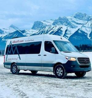 一辆货车停在一座白雪皑皑的山前