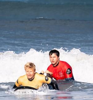two men in the ocean on surfboards in the ocean