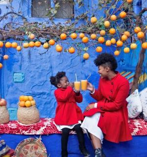 a man and a little girl sitting next to a blue wall