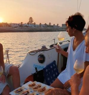 skupina lidí sedících na lodi s sklenicemi na víno