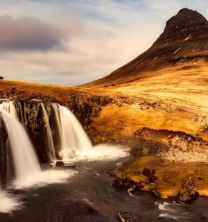 a waterfall in front of a mountain