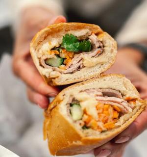 osoba držící dvě poloviny sendviče