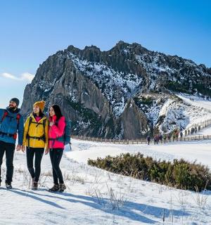 三个人站在山前的雪地里