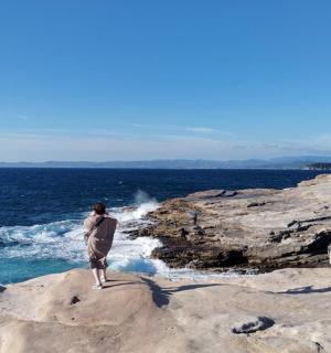 a man standing on a rock near the ocean