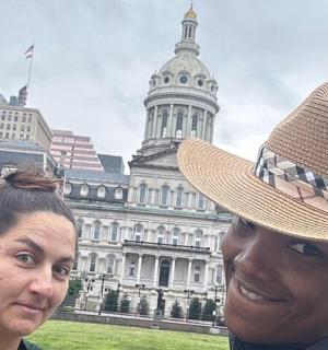 一位戴着帽子的女人站在一栋建筑前