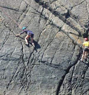two people are climbing on a rock formation