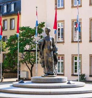 eine Statue vor einem Gebäude mit Flaggen