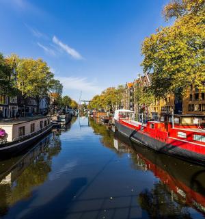 一艘红色的船停靠在一条有建筑物的运河中